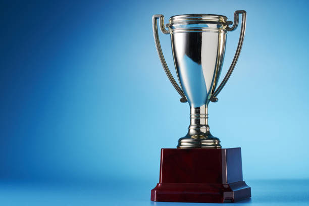 close up of golden trophy against blue background